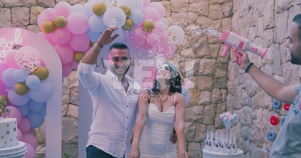 03-babyshower-event-pink-blue-yep-yepphotography Excited parents-to-be celebrating their baby's gender reveal, surrounded by festive pink and blue decorations or elements.