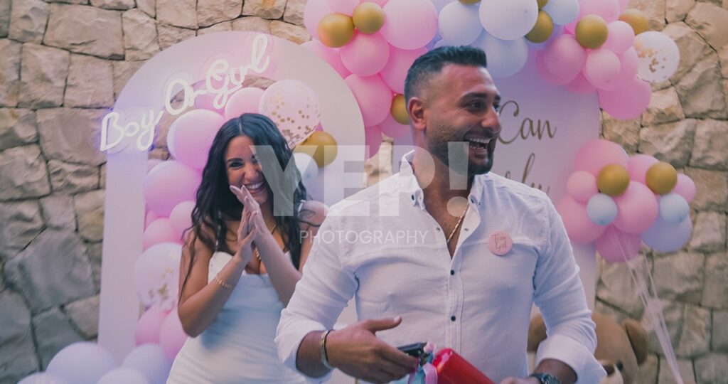 09-babyshower-event-pink-blue-yep-yepphotography Excited parents-to-be celebrating their baby's gender reveal, surrounded by festive pink and blue decorations or elements.