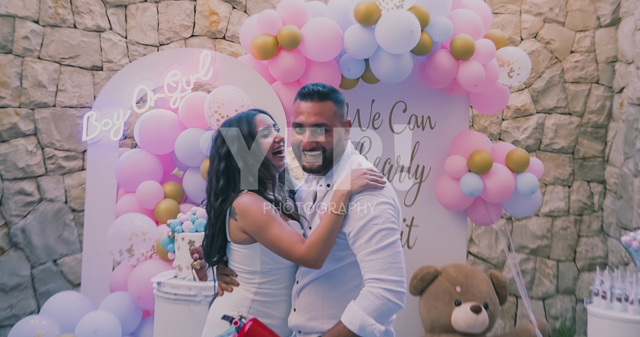 10-babyshower-event-pink-blue-yep-yepphotography-2 Excited parents-to-be celebrating their baby's gender reveal, surrounded by festive pink and blue decorations or elements.