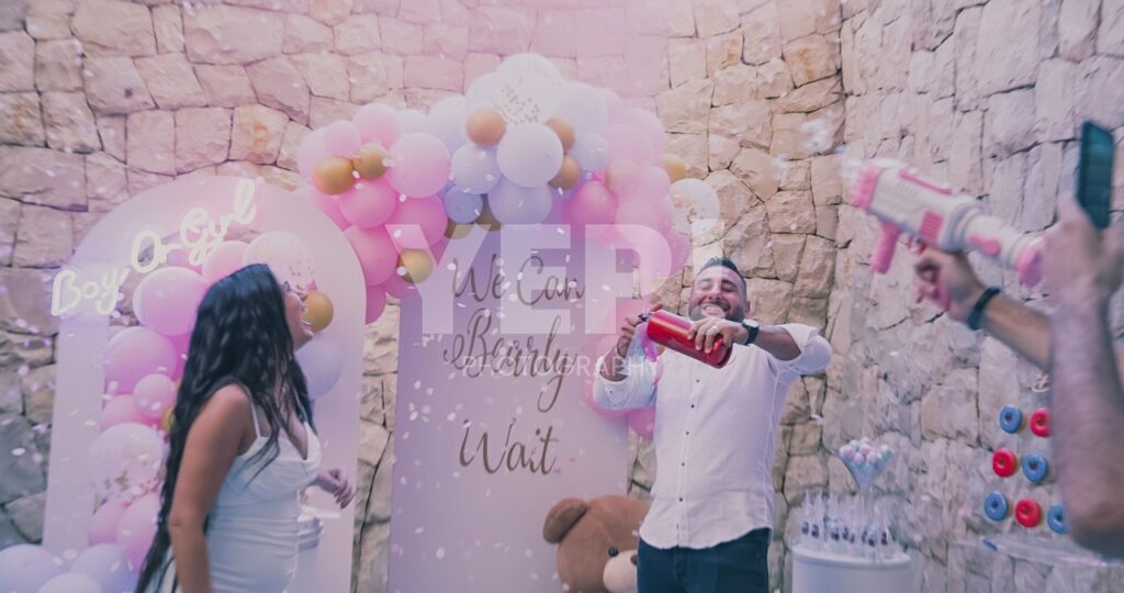 12-babyshower-event-pink-blue-yep-yepphotography Excited parents-to-be celebrating their baby's gender reveal, surrounded by festive pink and blue decorations or elements.