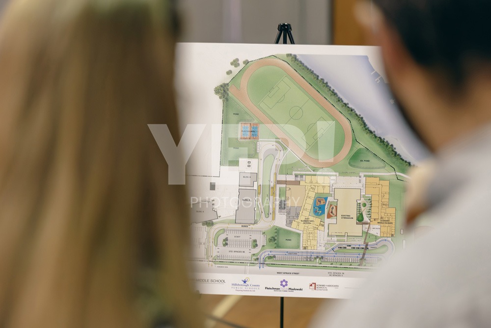 13-Skanska-school-opening-yepphotography-2 Skanska team members and architects unveiling modern design plans for a new school construction project at a reveal event.