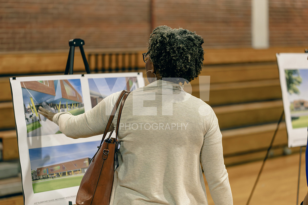 15-Skanska-school-opening-yepphotography Skanska team members and architects unveiling modern design plans for a new school construction project at a reveal event.