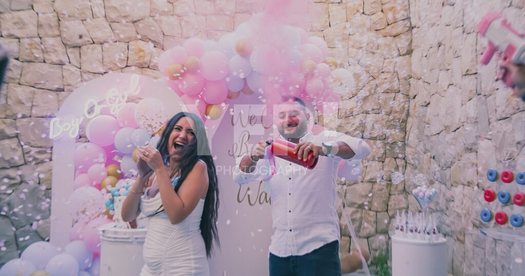 15-babyshower-event-pink-blue-yep-yepphotography Excited parents-to-be celebrating their baby's gender reveal, surrounded by festive pink and blue decorations or elements.