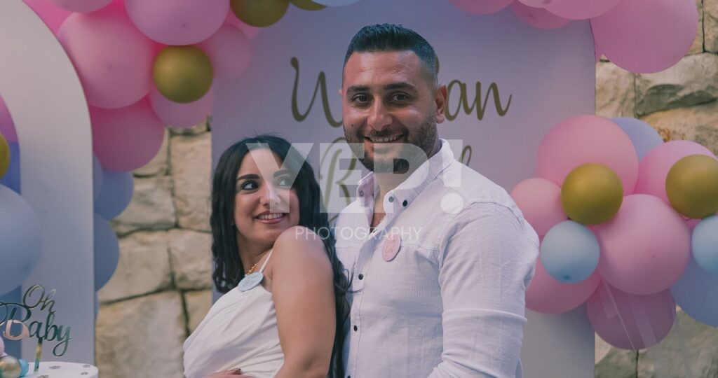 16-babyshower-event-pink-blue-yep-yepphotography Excited parents-to-be celebrating their baby's gender reveal, surrounded by festive pink and blue decorations or elements.