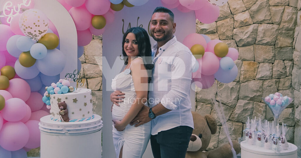 17-babyshower-event-pink-blue-yep-yepphotography-2 Excited parents-to-be celebrating their baby's gender reveal, surrounded by festive pink and blue decorations or elements.