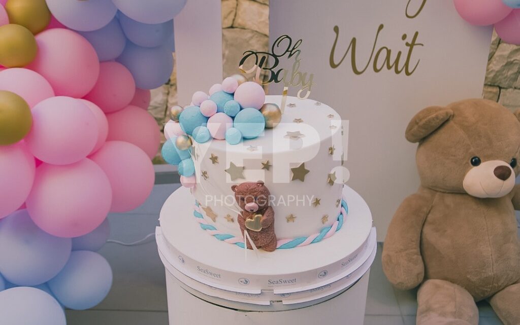 20-babyshower-event-pink-blue-yep-yepphotography Excited parents-to-be celebrating their baby's gender reveal, surrounded by festive pink and blue decorations or elements.