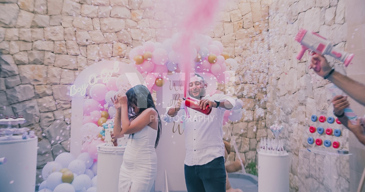 22-babyshower-event-pink-blue-yep-yepphotography-2 Excited parents-to-be celebrating their baby's gender reveal, surrounded by festive pink and blue decorations or elements.