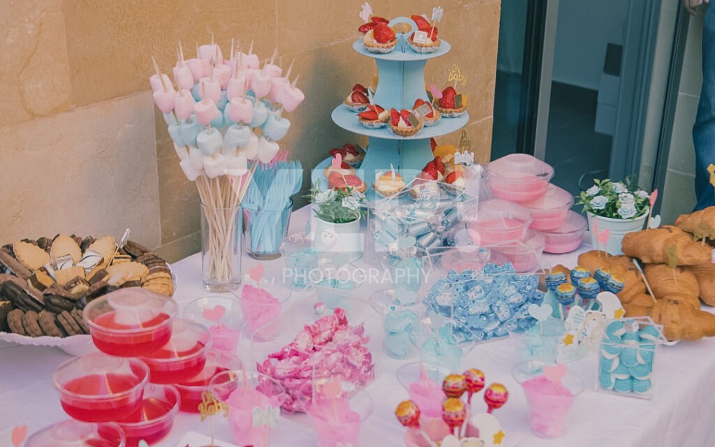 24-babyshower-event-pink-blue-yep-yepphotography Excited parents-to-be celebrating their baby's gender reveal, surrounded by festive pink and blue decorations or elements.
