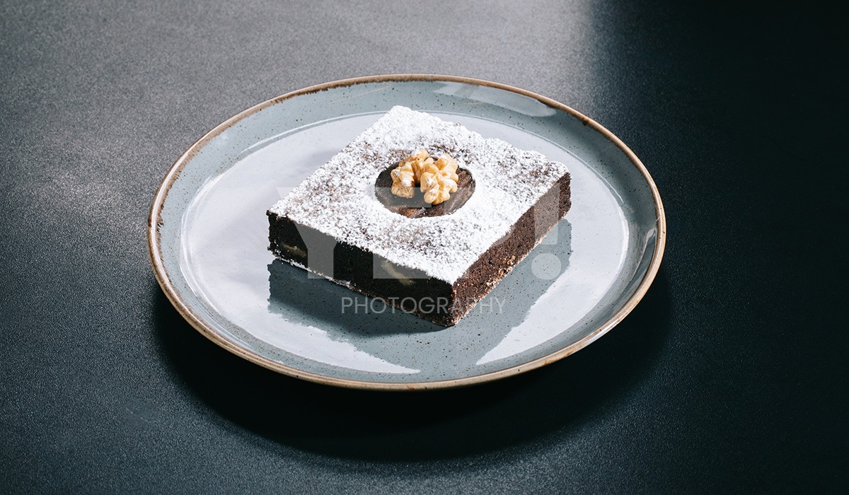 linascafe-linas-yep-yepphotography-gabrielsphotography-13 A freshly prepared healthy meal displayed on a dark surface in a modern restaurant environment, illuminated by soft ambient lighting.