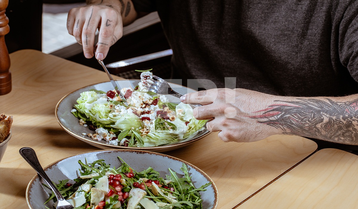 linascafe-linas-yep-yepphotography-gabrielsphotography-31 A freshly prepared healthy meal displayed on a dark surface in a modern restaurant environment, illuminated by soft ambient lighting.