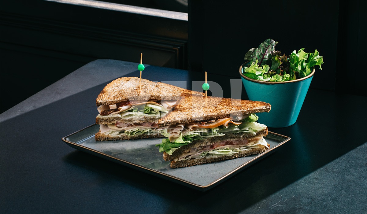 linascafe-linas-yep-yepphotography-gabrielsphotography-33 A freshly prepared healthy meal displayed on a dark surface in a modern restaurant environment, illuminated by soft ambient lighting.