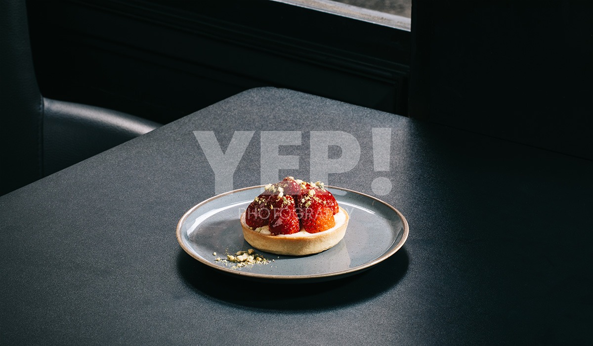linascafe-linas-yep-yepphotography-gabrielsphotography-7 A freshly prepared healthy meal displayed on a dark surface in a modern restaurant environment, illuminated by soft ambient lighting.